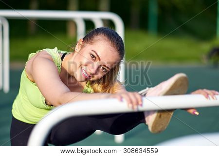Portrait Of Smiling Beautiful Stretching Danser Or Gymnast Woman Training In Workout Sports Ground