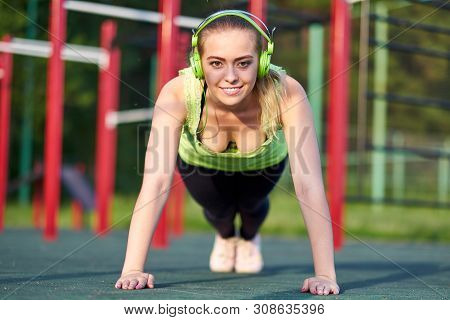 Stretching Woman Training Trains In Workout Sports Ground. Doing Exercise Plank