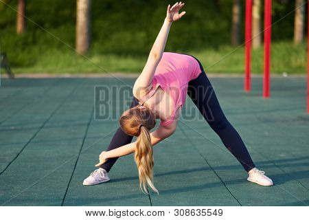 Portrait Of Fit And Sporty Young Woman Doing Stretching In Workout Sports Ground