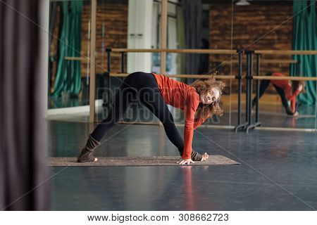 Woman Stretching In Parsvottanasana Or Intense Side Stretch Pose At Yoga Studio