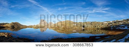 Midi Dossau Peak reflected in a lake. Ossau Valley, Pyrenees National Park, Pyrenees, France.