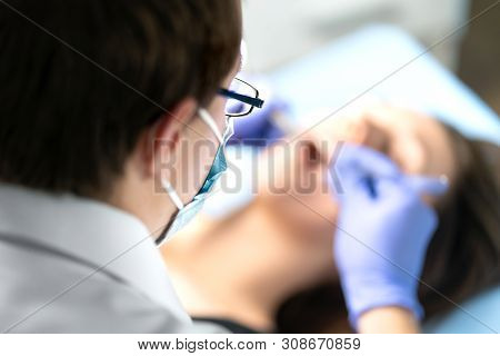 Dentist Or Dental Hygienist In Operation With Patient. Woman With Calculus Or Caries. Oral Doctor Re