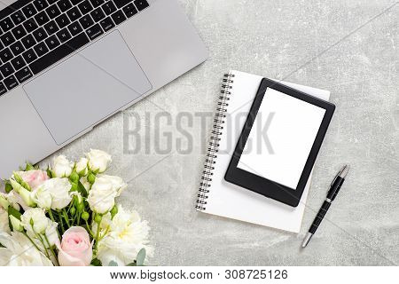 Office Desk Table With Laptop Computer, Blank Copy Space Mockup Screen Tablet, Flowers And Supplies 