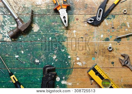 Flat Lay Set Of Vintage Carpentry Tools On Colorful Wooden Background. Top View Workbench With Carpe
