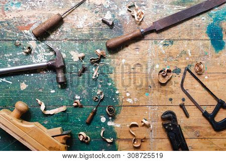 Flat Lay Set Of Vintage Carpentry Tools On Colorful Wooden Background. Top View Workbench With Carpe