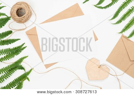 Flat Lay Fashion Office Desk. Female Workspace With Blank Paper Card, Craft Envelope, Green Flower B