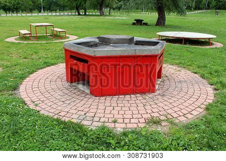 Public Park With Multiple Open Concrete And Metal Barbecues For Public Use Surrounded With Stone Til