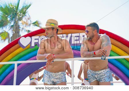 The Annual Parade Lgbt. Two Gay Men In Pride Parade. Parade Of Tolerance. Rainbow Flags At Gay Pride