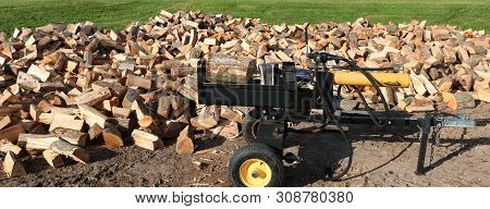 Wood Splitter With Maple Block On Platform Ready To Slice And Heaps Of Split Wood Around It On The G