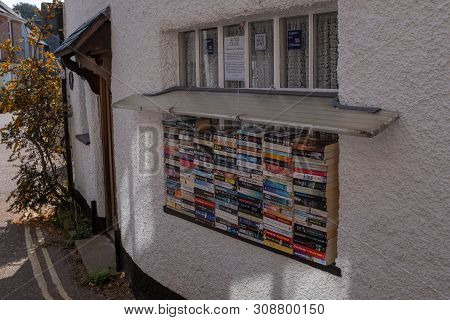 Lympstone, Devon, Uk, April, 8, 2019: A Pile Of Various Books For Sale On A Window Sill In A Village