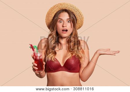 Young European Woman Wearing Red Swimming Suit And Straw Hat Being Shocked Due To Imminent Danger, H