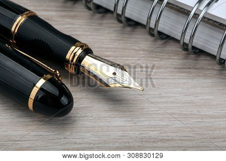 Fountain Pen Near The Notepad On A Wooden Table  Closeup