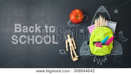 Back To School Concept With Small Bag Backpack, School Supplies And Rocket Sketch Over Chalkboad Bac