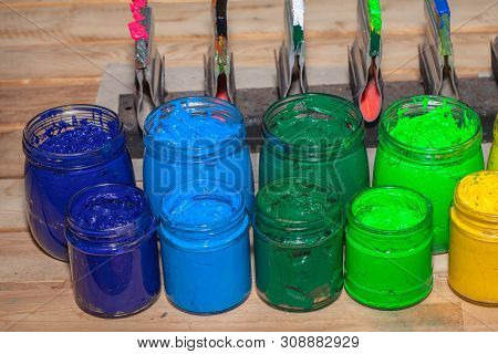 Colorful Plastisol Ink In Transparent Bottles In Screen Printing Tee Shirt Factory Store.