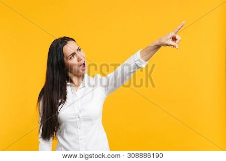 Portrait Of Screaming Angry Young Woman In White Casual Shirt Looking, Pointing Index Finger Aside I