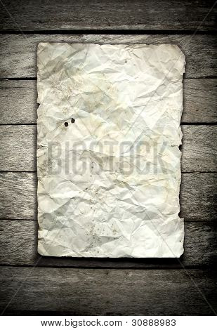 antigo papel amassado na parede de madeira