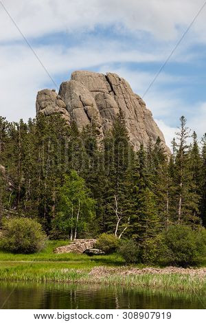 Sylvan Lake Shore Line With A Rock Masonry Walk Bridge And Tall Evergreen Trees And A Large Granite 