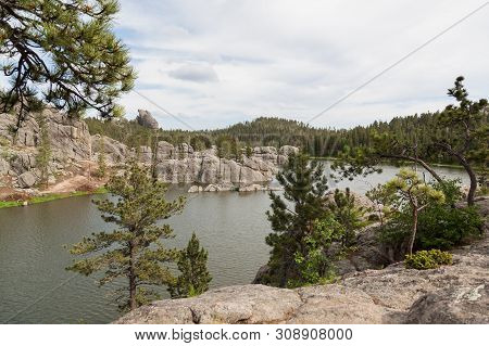 Large Granite Rock Formations And Trees Along The Shoreline Of  Sylvan Lake In South Dakota.