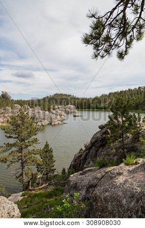 Large Granite Rock Formations And Trees Along The Shoreline Of  Sylvan Lake In South Dakota.