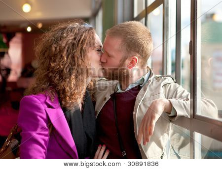 หนุ่มสาวคู่รัก Kisssing ใกล้หน้าต่างภายใน