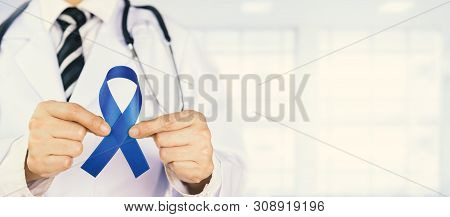 Doctor Holds Blue Ribbon,  Colon Cencer Awareness. Symbolic Concept Raising Awareness Concerns Help 