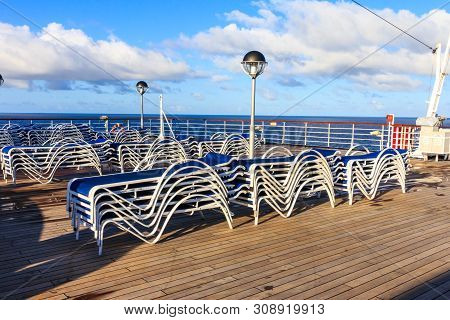 Sunbeds On A Teak Deck Of A Cruise Ship In The South Pacific