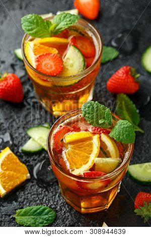 Refreshing Pimms Cocktail With Fruit And Vegetables On Rustic Black Table