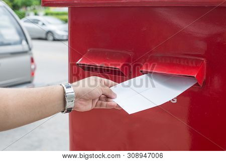 Man Sending Mail In The City.a Man Sending A Letter And Documents Via Mailbox.