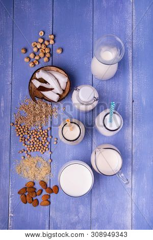Types Of Vegetable And Organic Milk In Glass Containers On A Light Blue Wooden Table