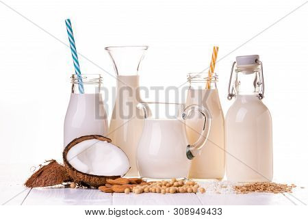 Types Of Vegetable Milk, And Organic, In Glass Containers On The Table In White Wood