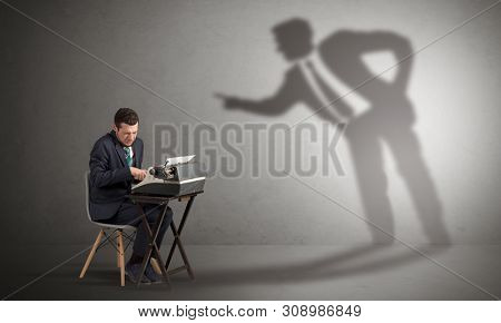 Little man working and a big shadow arguing with him