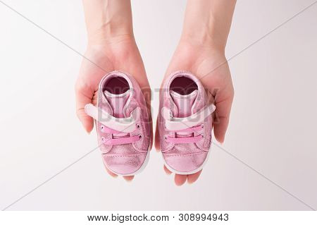 Children's Sneakers Closeup. Children's Shoes In The Hands Of Women.
