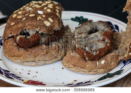 Close Up Of A Kroket On Bun On A Plate