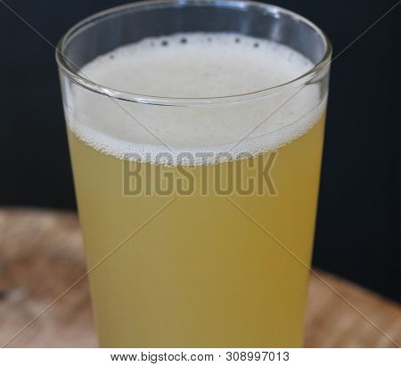 Close Up Of Glass Filled With Radler, Mixture Of Beer And Sparkling Lemonade, On Wooden Background
