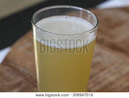 Close Up Of Glass Filled With Radler, Mixture Of Beer And Sparkling Lemonade, On Wooden Background