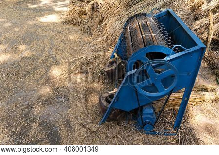 Paddy Threshing Machine With Electric Motor At Farmer's Rice Farm In India Behind Hay Stack