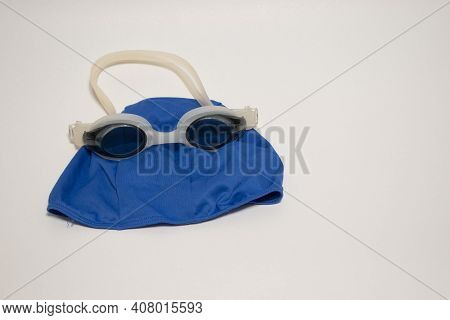 Professional White Glasses For Swimming And Blue Swimming Cap . White Swim Goggle Isolated On White 