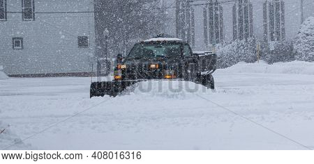 A Private Contracter Is Plowing The Snow In A Parking Lot For The Local Businesses.