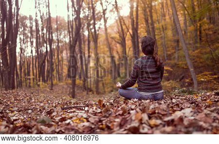 connect with mothernature and breathing fresh air, woman meditating in forest. Busting energy.