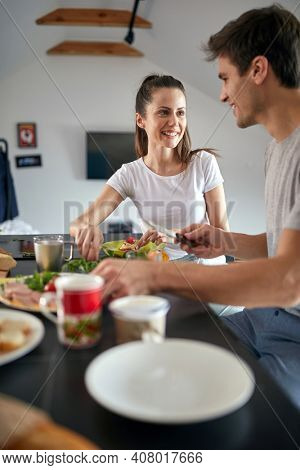 Cheerful romantic cople having breakfast together at home