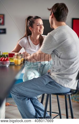 Joyful cople having breakfast together at home