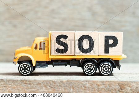 Toy Truck Hold Alphabet Letter Block In Word Sop (abbreviation Standard Operating Procedure) On Wood