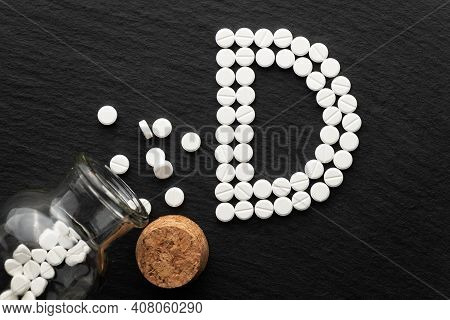 Vitamin D Lettering Lined With Pills On Slate Background