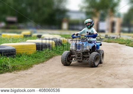 A Child Rides An Atv On The Track