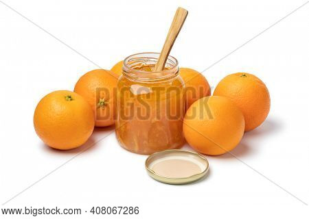 Homemade orange marmelade in glass jar and fresh oranges in the background