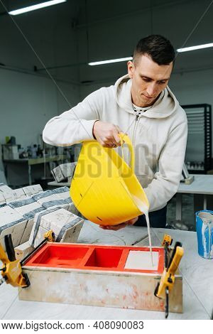 Man Pouring Gypsum Plaster In Open Form For Mold Casting For Making Tableware.