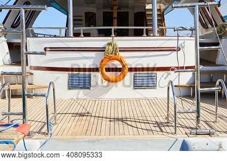 View Of The Stern Of The Yacht. Lifebuoy And Ropes Hang Neatly On The Yacht