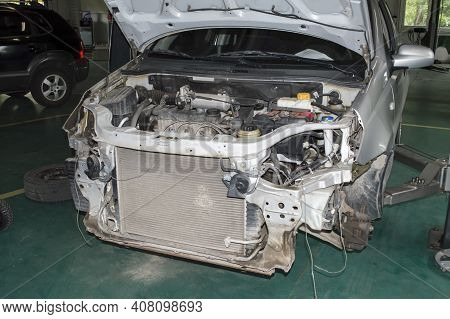 View Of The Engine Compartment Of A Gray Car With The Front Bumper Removed Which Is Installed On The