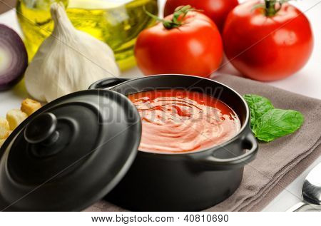 Soupe de tomate dans une casserole noire et ingrédients