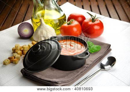 Soupe de tomate dans une casserole noire et ingrédients